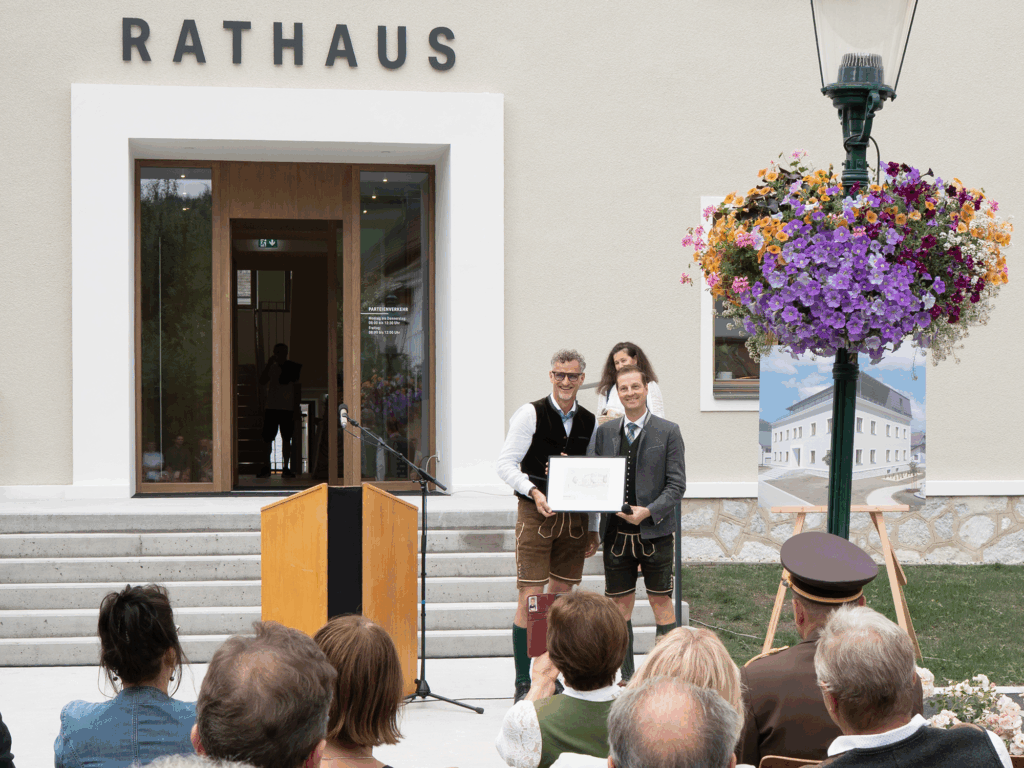 Architekt DI Gerhard Kreiner überreicht Bürgermeister Thomas Reingruber ein Geschenk zur Wiedereröffnung des Rathauses.